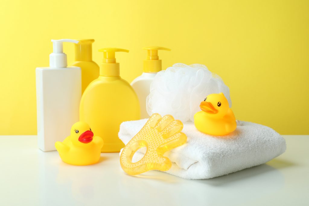 Different baby hygiene accessories against yellow background